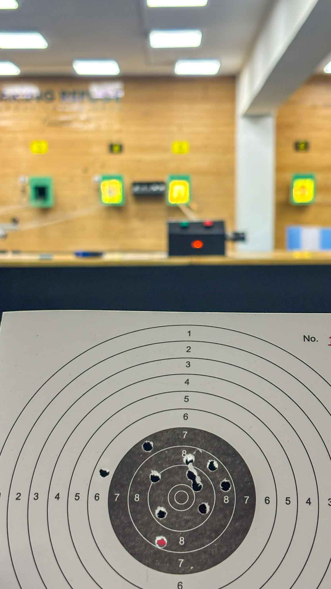Closeup of a target paper with shooting holes, showcasing accuracy at the shooting range.